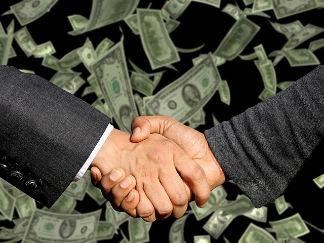 picture of handshake in front of dollar bills