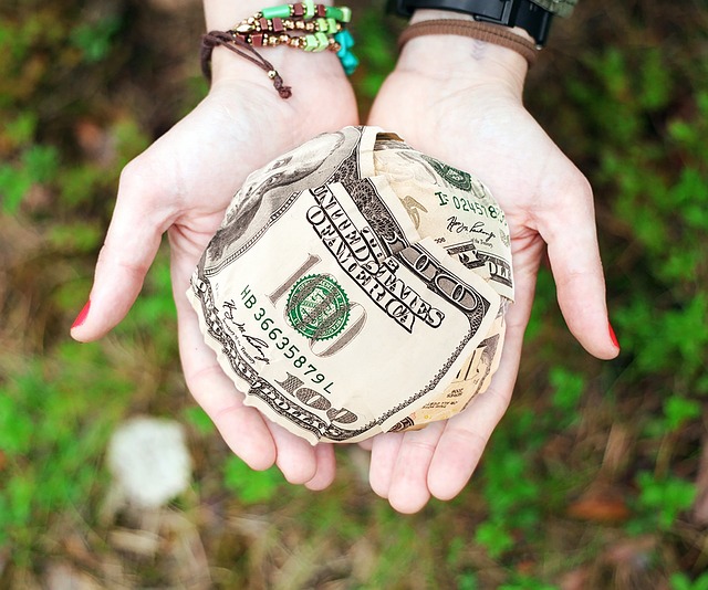 picture of open hands with crumpled up american money