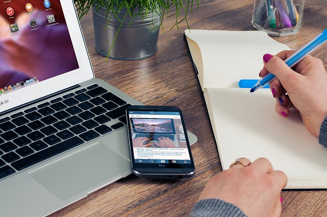 picture of someone using a notepad beside their laptop